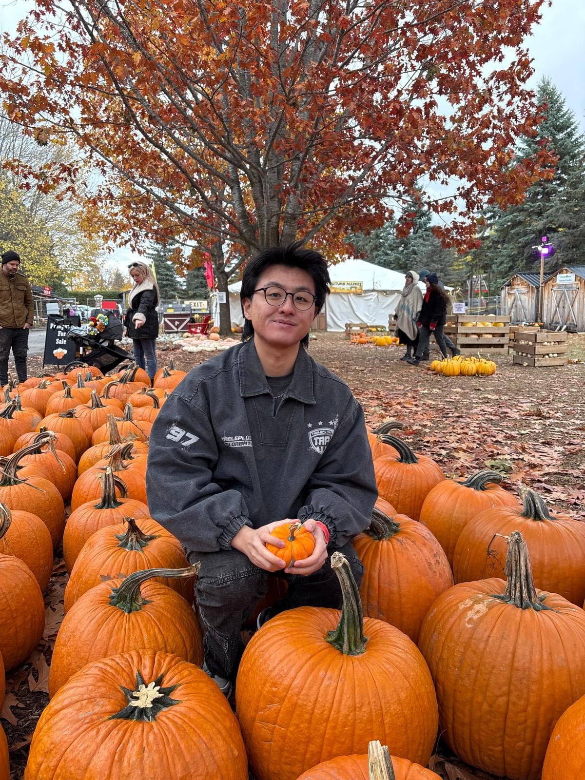 Justin at a pumpkin patch surrounded by pumpkins